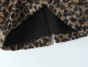 Détail d'une jupe à imprimé léopard avec tissu en fausse fourrure et fente d'ourlet