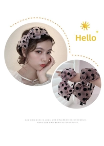 Detail of elegant mesh headband with oversized polka dot bow on female model