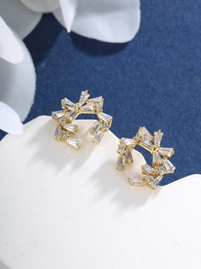 Detailed macro view of gold-plated flower stud earrings with shimmering zircon crystals