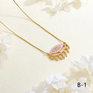 Detailed close-up of pink enamel Evil Eye necklace with leaf tassels on white texture