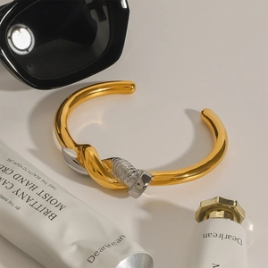 Polished two-tone gold and silver knot nail bangle in 18k plated stainless steel