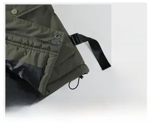 Detailaufnahme der olivgrünen Weste mit Metall-Druckknöpfen und glattem Reißverschluss
