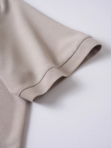 Close-up of khaki waffle knit fabric and durable stitching on short sleeve polo shirt cuff