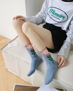 Detailed close-up of blue cotton crew socks featuring pink floral tulip patterns