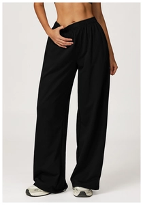 Detail of high-waist black wide-leg sweatpants with elastic drawstring waistband