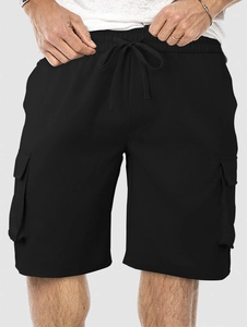 Detail of men's black cargo shorts featuring elastic drawstring waist and large side pockets