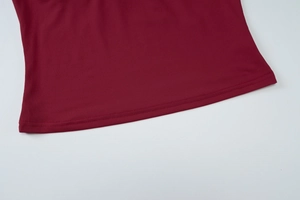 Detail of burgundy top hem showing precise double-needle stitching and fabric texture