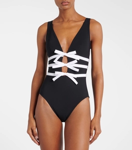 Detailed view of the deep V-neckline and white bow hollow cut-out on black swimsuit