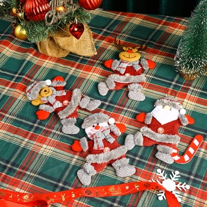 Close-up of four plush Christmas ornaments featuring Santa, snowman, bear, and reindeer