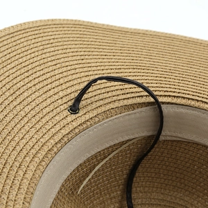 Macro view of woven straw hat featuring inner sweatband and adjustable drawstring tie