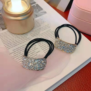 Elegant rhinestone hair ties in blue and white on a magazine with pink storage box