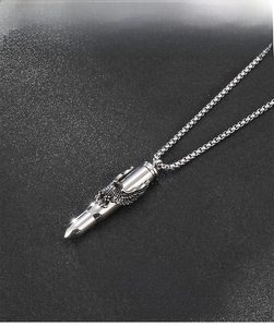 Macro shot of silver bullet pendant with detailed eagle engraving on stainless steel chain