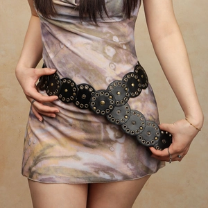 Detail of vintage black punk belt with antique gold studs on leather circular discs
