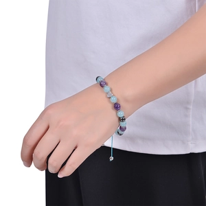 Detail of beaded bracelet with rose quartz, heart charm, and adjustable blue cord