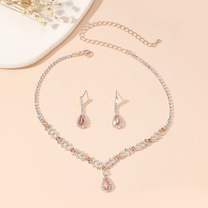 Detail of rose gold jewelry set with pink teardrop gems and sparkling rhinestones