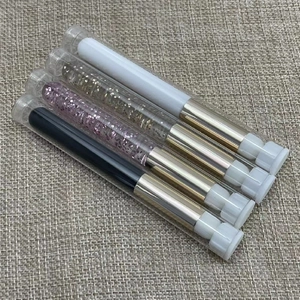 Set of 5 colorful portable round lip brushes in protective tubes on a textured surface