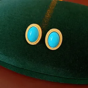 Vintage oval turquoise studs with gold twisted rope border on luxury green velvet