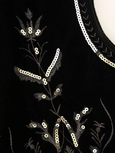 Close-up of golden and silver sequin floral embroidery on premium black velvet fabric