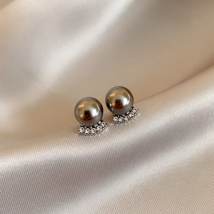 Macro detail of elegant dark grey pearl stud earrings with sparkling rhinestone base