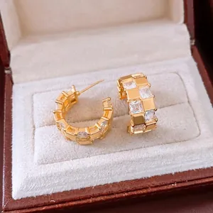 Boucles d'oreilles créoles C dorées 18k avec zircons carrés sur boîte en velours