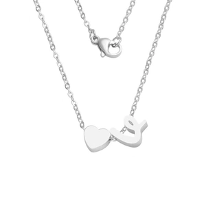 Macro detail of silver stainless steel heart and cursive letter L pendant necklace