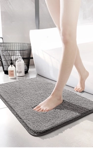 Close-up of feet on a thick grey microfiber bath mat showing soft texture and high density