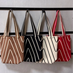 Detailed view of four color variants of the knit tote bag with white V-pattern textures