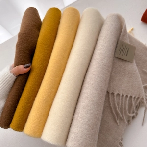 Soft 100% Australian wool scarves in assorted warm colors featuring classic fringed edges