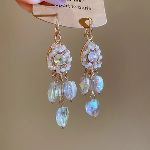 Detailed view of gold tassel earrings with teardrop crystal and shimmering pearls