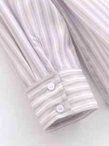 Detailed macro view of gray and white striped cotton shirt cuff with double button closure