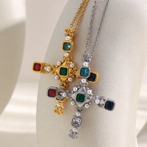 Detail of 18K gold and silver cross necklaces with colorful gemstones and white pearls