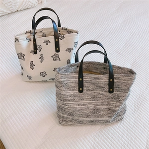Détail du sac cabas en toile avec broderie papillon et sacs en tissu tweed texturé