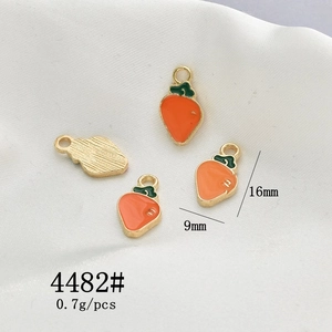 Detailed view of carrot alloy charm with orange enamel and gold base for DIY jewelry