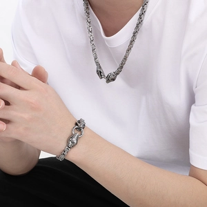 Detailed view of silver stainless steel weave chain with double snake head clasps on a model