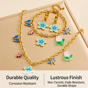 Détails d'une parure de bijoux dorés avec pendentifs colorés en émail (fleurs et papillons)