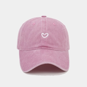 Close-up of heart embroidery on washed cotton fabric of the pink baseball cap
