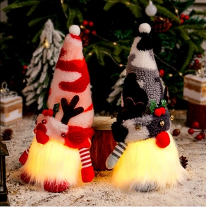 Close-up of glowing Christmas gnomes with reindeer antlers and festive hats on snow
