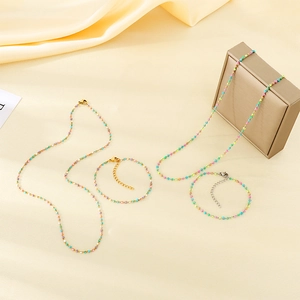 Détail d'un ensemble de colliers et bracelets en perles colorées sur tissu en soie