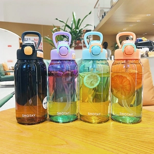 Four colorful Tritan sports bottles with handles and straws on a wooden table