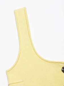 Detailed close-up of bright yellow knit fabric texture and dark metallic buckle