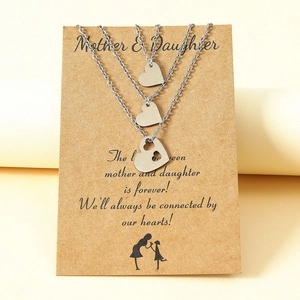 Detailed view of silver heart puzzle necklaces for mother and daughters on craft card