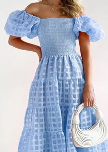 Close-up of light blue off-shoulder dress with puff sleeves and layered checkered texture