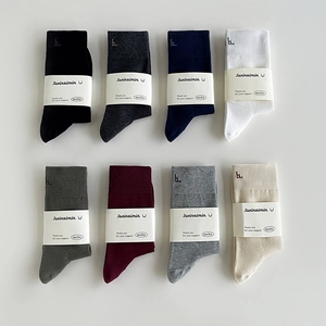 Eight pairs of solid cotton mid-calf socks in diverse colors with subtle logo embroidery