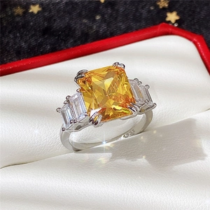Close-up of S925 silver ring with yellow square-cut stone and side baguettes in a box