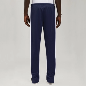 Detail view of navy blue polyester joggers with white side stripes and elastic waist