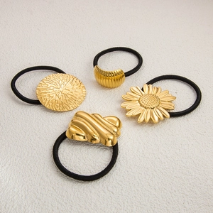 Four gold stainless steel floral and geometric hair ties with black elastic bands
