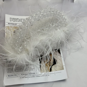Detail of white beaded handbag featuring soft ostrich feathers for evening party wear