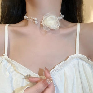 Close-up of white tulle rose choker with faux pearls for women's elegant necklace