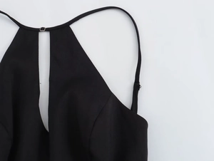 Gros plan de la robe noire avec une encolure découpée sexy et des bretelles fines