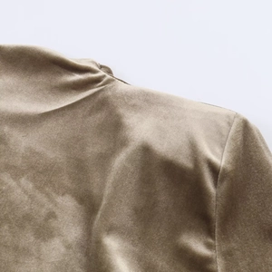 Detailed close-up of champagne velvet fabric showing padded shoulder and premium texture